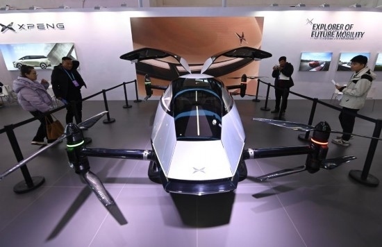 2023年12月1日，在鏈博會(huì)智能汽車鏈展區(qū)小鵬汽車展臺，參觀者觀看一臺智能飛行器。新華社記者蔡湘鑫攝