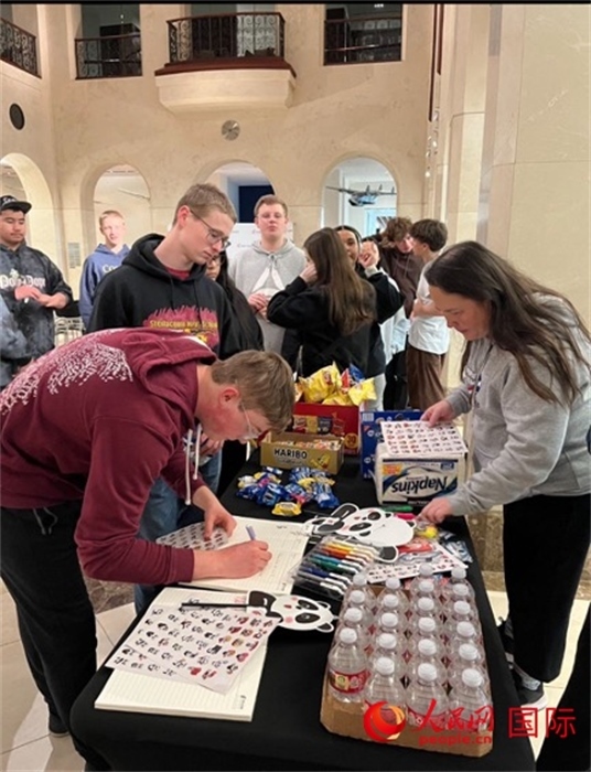 學生們出發(fā)前紛紛在留言簿留言。人民網(wǎng)記者 鄧圩攝