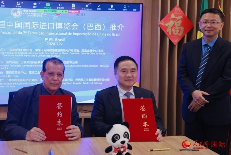 巴西外貿商會聯(lián)合會會長阿代爾·羅伯托（左）與中國國際進口博覽局副局長吳政平（中）現(xiàn)場簽訂協(xié)議。人民網(wǎng)記者 宋亦然攝
