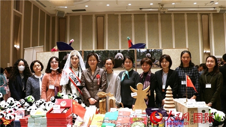 中國駐日本大使吳江浩夫人丁玥（左五）與使館人員在展位前合影留念。人民網(wǎng) 許可攝