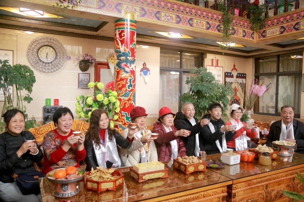 游客們?nèi)胱∶袼藓螅e杯共飲酥油茶。新華社記者 邱星翔 攝