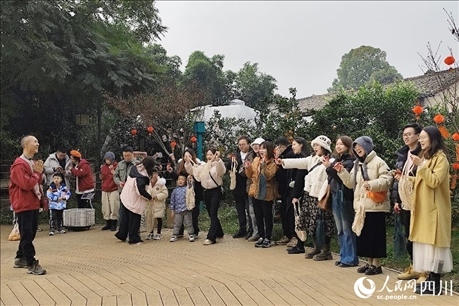 葉科（左一）給前來(lái)參與活動(dòng)的“柑爸柑媽”介紹生態(tài)種植果。人民網(wǎng)記者朱虹攝