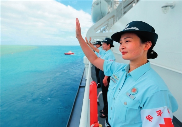 中國海軍“和平方舟”號醫(yī)院船結(jié)束訪問湯加時，任務(wù)官兵中的文職人員向歡送人群揮手告別（2023年8月4日攝）。徐巍攝/本刊