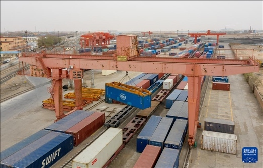 4月21日，二連浩特鐵路口岸龍門吊吊裝中歐班列集裝箱（無人機照片）。 新華社發(fā)（張海峰攝）