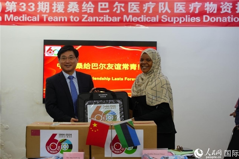 江蘇省蘇北人民醫(yī)院黨委書(shū)記束余聲捐贈(zèng)物資與桑衛(wèi)生部首席秘書(shū)哈比巴。中國(guó)援桑醫(yī)療隊(duì)供圖