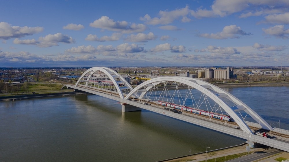 2024年3月12日，一列火車運(yùn)行在匈塞鐵路塞爾維亞境內(nèi)貝諾段諾維薩德多瑙河大橋上（無人機(jī)照片）。新華社發(fā)（任衛(wèi)云攝）