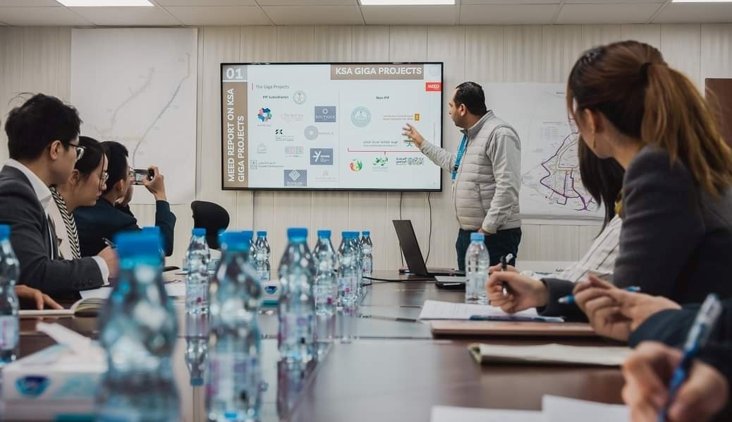 德亞（右三）在和員工開會。中建中東沙特分公司供圖