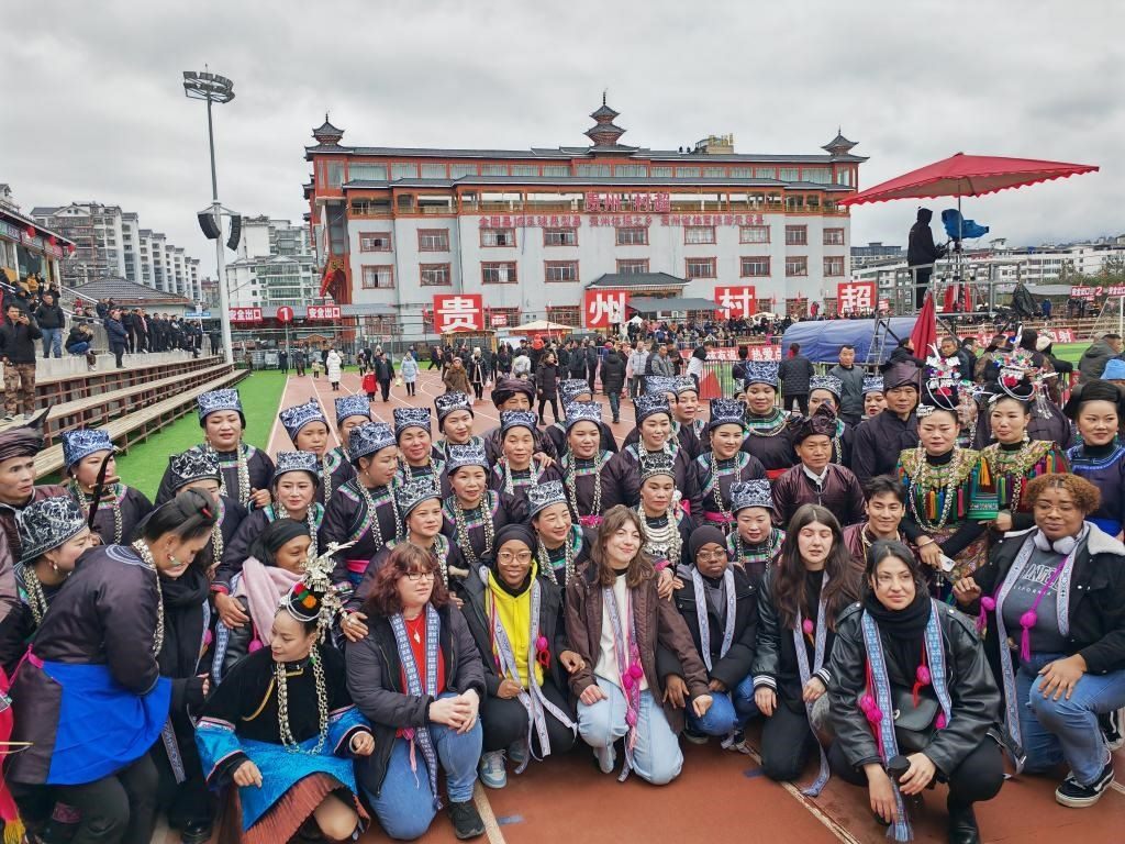 法國青年在“村超”賽場邊與參加表演的村民合影。新華社記者 羅羽 攝