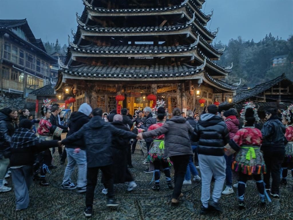 法國青年與當?shù)卮迕駹渴痔?。新華社記者 羅羽 攝