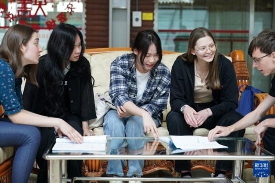 4月28日，宋智孝（右二）和胡靈月（左一）在北京首都師范大學校園內與同學交流。新華社記者 彭子洋 攝