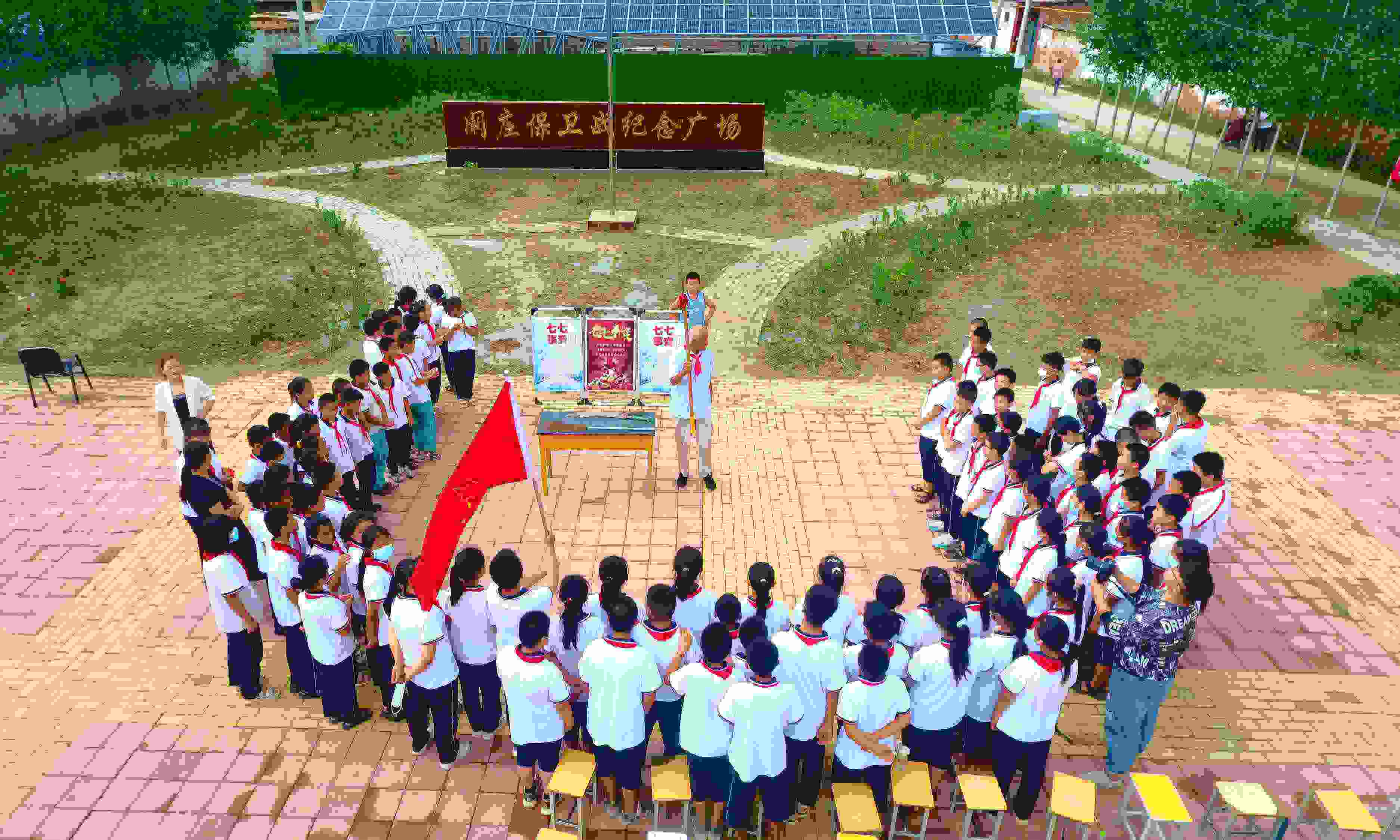 2022年7月6日，山東省聊城市，在茌平區(qū)菜屯鎮(zhèn)闞莊村的闞莊保衛(wèi)戰(zhàn)紀念廣場，闞莊保衛(wèi)戰(zhàn)親歷者王光木老人為小學(xué)生們講述抗戰(zhàn)故事，展示大刀、長矛。