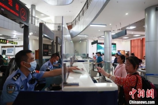 圖為旅客在磨憨口岸辦理通關(guān)手續(xù)。雷雨 攝