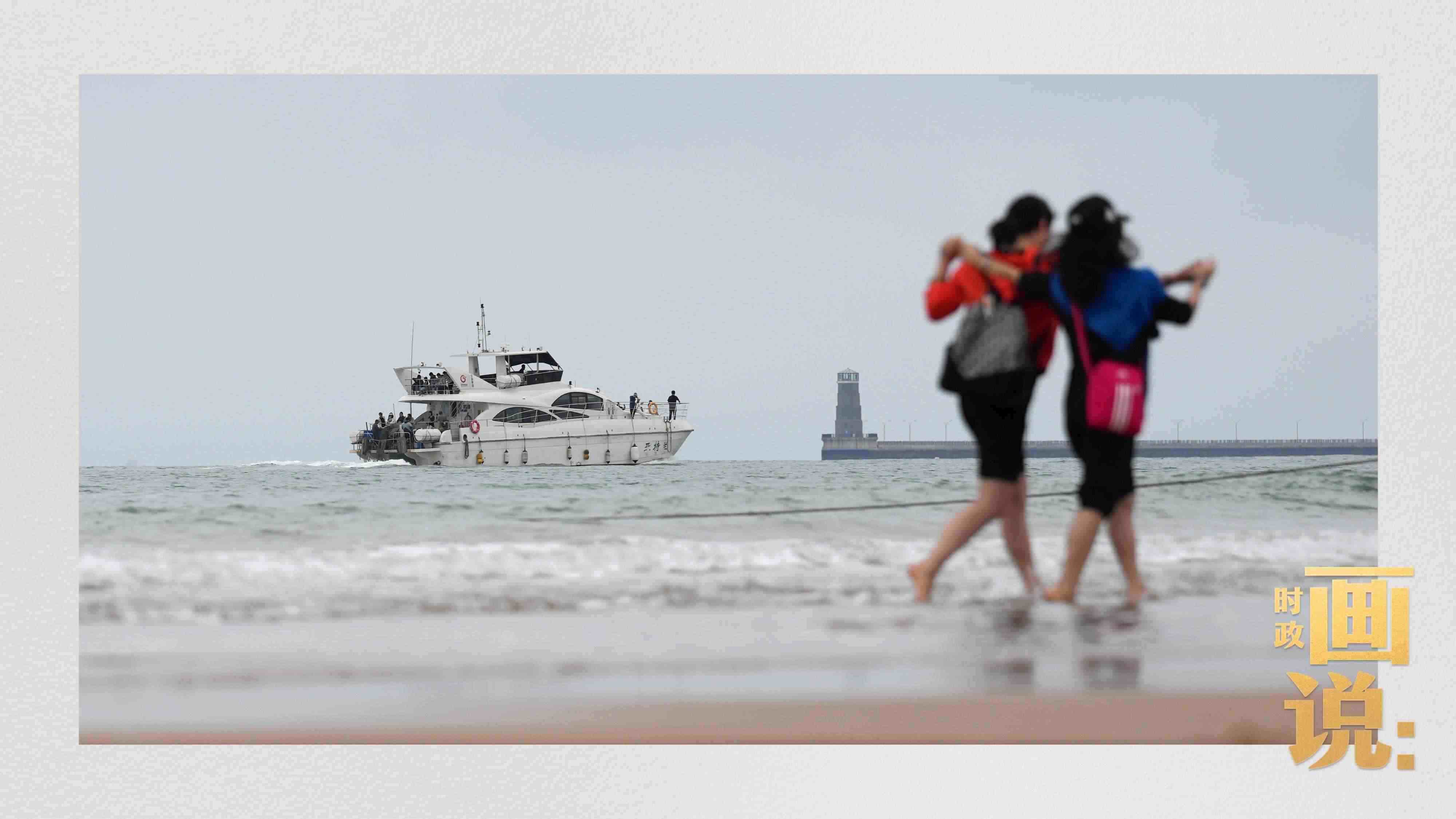 △日照陽(yáng)光海岸綠道上的萬(wàn)平口景區(qū)，一對(duì)游客在海浪中翩然起舞。