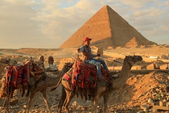 1月24日，商販騎駱駝離開埃及吉薩金字塔景區(qū)。新華社記者 隋先凱 攝
