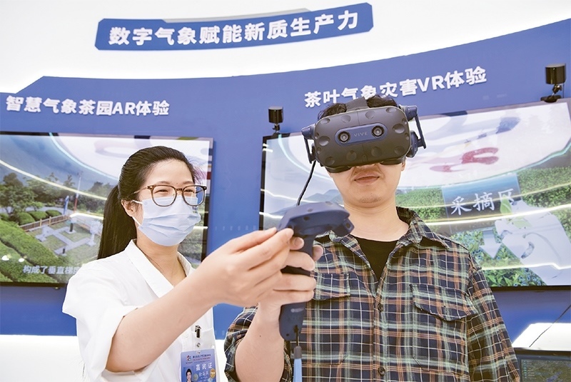 2024年5月23日，第七屆數(shù)字中國建設(shè)峰會現(xiàn)場體驗區(qū)在福州海峽國際會展中心向?qū)I(yè)觀眾開放。本次現(xiàn)場體驗區(qū)圍繞本屆峰會主題“釋放數(shù)據(jù)要素價值，發(fā)展新質(zhì)生產(chǎn)力”，設(shè)置“數(shù)字惠民”、“數(shù)字能力”、“數(shù)字基礎(chǔ)”、“數(shù)字生態(tài)”、“數(shù)字賦能”五大板塊。圖為一名觀眾（右）在數(shù)字氣象賦能新質(zhì)生產(chǎn)力展臺上進行體驗。 新華社記者 魏培全/攝