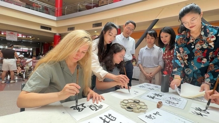 羅馬尼亞友人在活動(dòng)現(xiàn)場(chǎng)學(xué)寫(xiě)漢字。中國(guó)駐羅馬尼亞大使館領(lǐng)僑處供圖