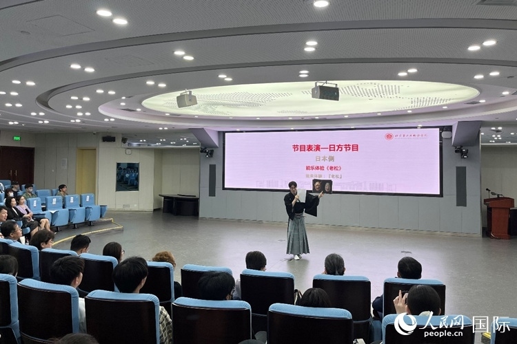 日本大學(xué)生介紹能樂知識。人民網(wǎng)記者 陳思攝