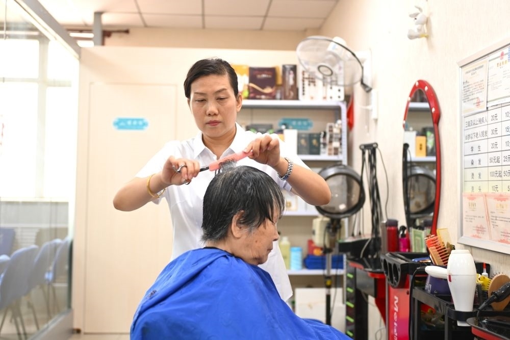 6月20日，長城花園社區(qū)的志愿者為居民理發(fā)。
