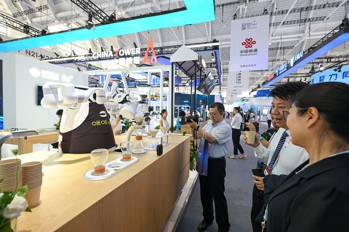 6月20日，與會(huì)者品嘗機(jī)器人沖調(diào)出的咖啡。新華社記者 孫凡越 攝