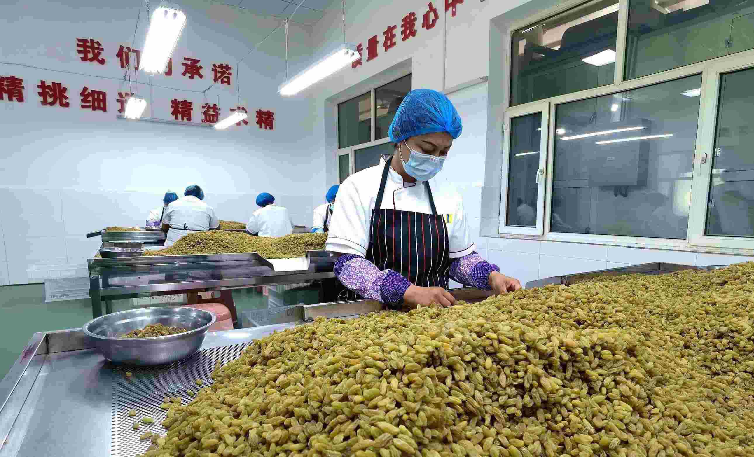 新疆吐魯番市高昌區(qū)亞爾鎮(zhèn)新城西門(mén)村，村民們?cè)诜謷咸迅伞? width=