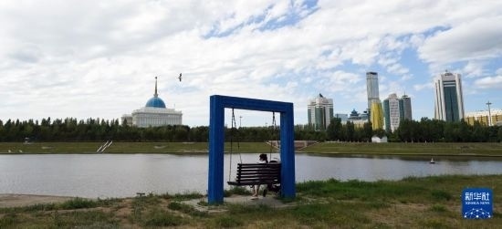 6月30日，一名女子在哈薩克斯坦首都阿斯塔納伊希姆河畔休息。新華社記者 王建華 攝