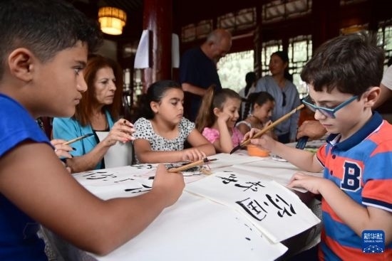 7月4日，在馬耳他桑塔露琪亞市的中國古典園林“靜園”，人們體驗中國書法。新華社發(fā)（喬納森·博格 攝）