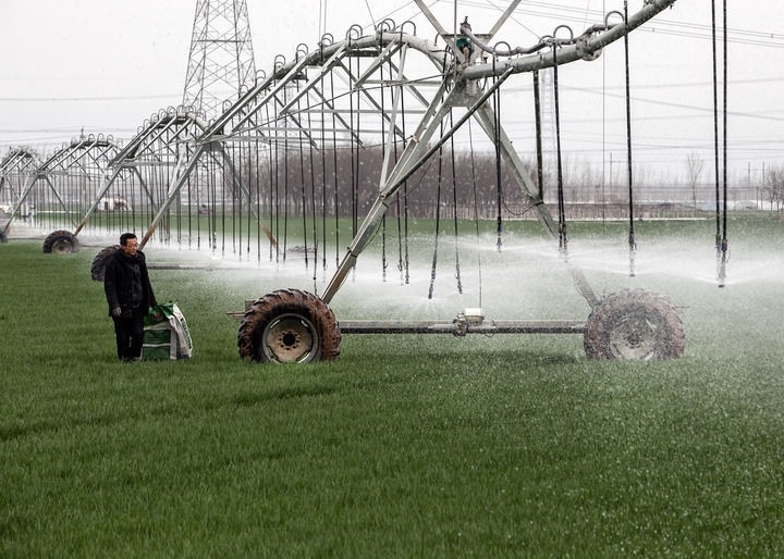 2024年3月18日，在河南省焦作市博愛縣孝敬鎮(zhèn)東原莊村瑞輝家庭農(nóng)場，村民使用全自動指針式噴灌機(jī)進(jìn)行澆灌作業(yè)。新華社發(fā)（程全攝）