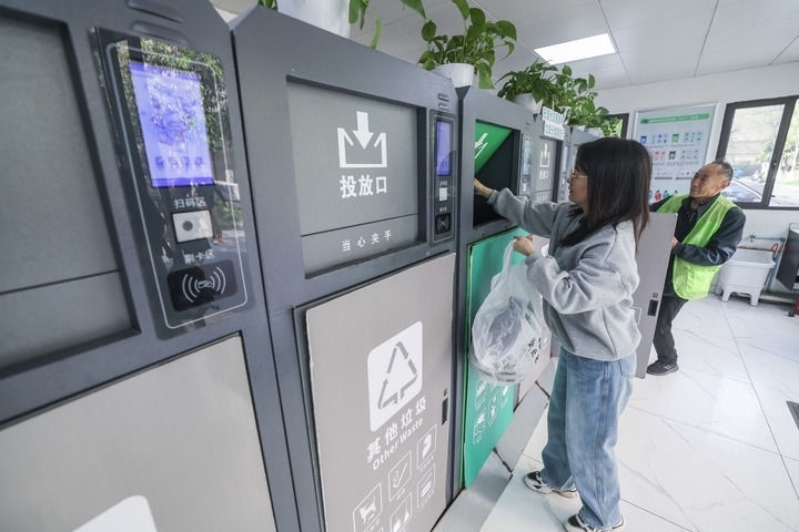 2024年4月10日，在浙江省湖州市吳興區(qū)飛英街道新華府小區(qū)內(nèi)，居民在垃圾分類智能系統(tǒng)的指導(dǎo)下進(jìn)行垃圾分類投放，居民的投放情況將實(shí)時匯總到智慧服務(wù)平臺，會有相應(yīng)的積分獎勵。新華社記者 徐昱 攝