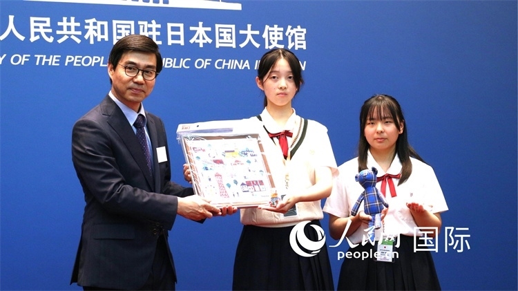 日本小大使向中國駐日本大使館臨時(shí)代辦施泳贈(zèng)送當(dāng)?shù)靥厣Y品。人民網(wǎng) 許可攝