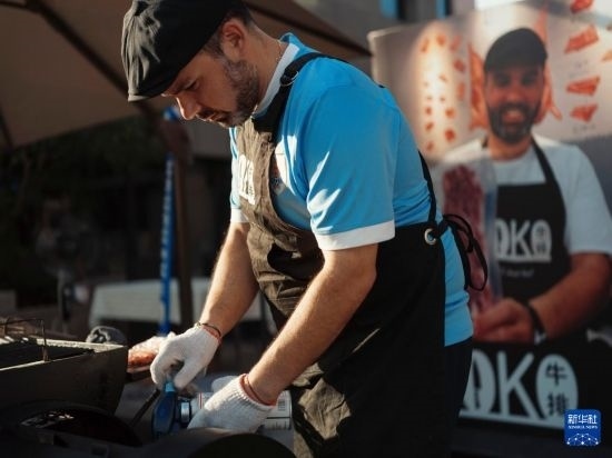 7月19日，在蕪湖古城，馬丁在當(dāng)天舉行的啤酒節(jié)上制作牛排。新華社發(fā)（繆雨晨 攝）