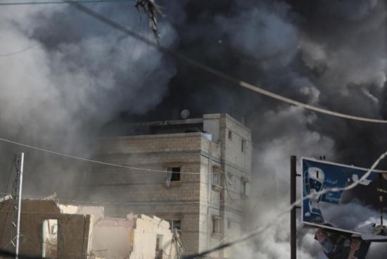 7月21日，在加沙地帶中部的努賽賴特難民營，遭以軍空襲的建筑冒出滾滾濃煙。新華社發(fā)（馬爾萬·達烏德攝）