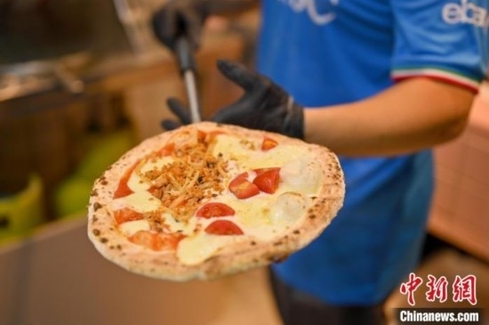 近日，韋榮耀展示他制作的“老友味”披薩。 俞靖 攝
