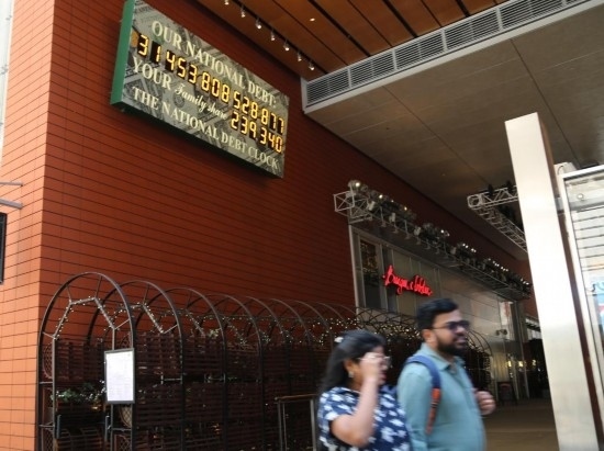 2023年5月29日，人們經(jīng)過美國紐約曼哈頓的“國債鐘”?！皣鴤姟笔且粋€大型計數(shù)器，它實時更新美國的公共債務(wù)總額，并顯示出每個美國家庭所要負擔的數(shù)額。 新華社記者劉亞南攝