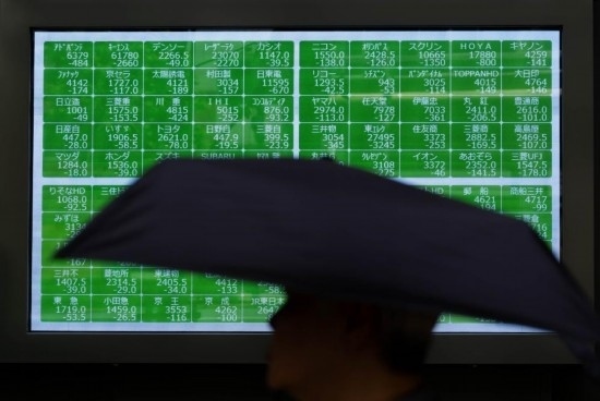 8月2日，在日本東京，行人經(jīng)過(guò)一處股指信息電子顯示屏。新華社記者張笑宇攝