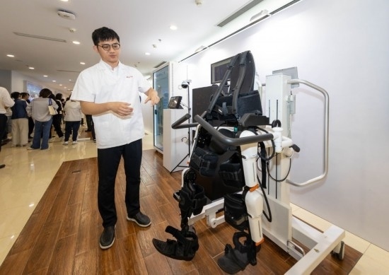 2024年5月24日，在位于上海市嘉定區(qū)的上海交通大學醫(yī)學院附屬瑞金醫(yī)院腫瘤質(zhì)子中心，工作人員介紹由瑞金醫(yī)院醫(yī)生和醫(yī)療公司共同研發(fā)的用于恢復患者下肢的醫(yī)療機器人。新華社記者 王翔 攝