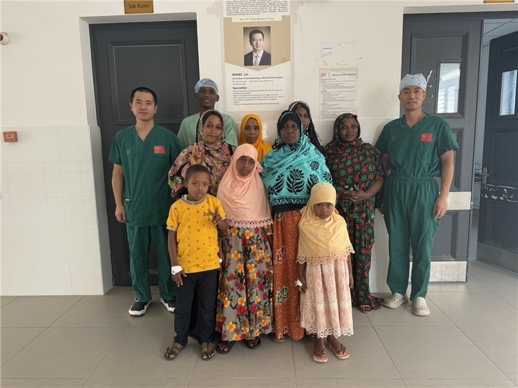 李廣（右一）和王林醫(yī)生與部分患者合影。中國(guó)援桑醫(yī)療隊(duì)供圖