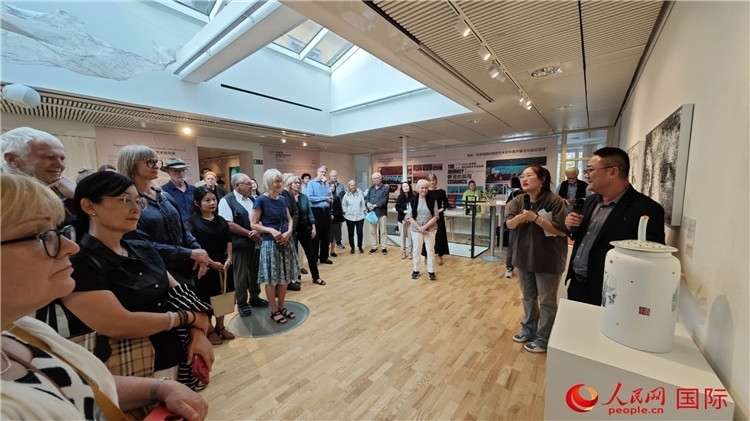 參展人、景德鎮(zhèn)陶瓷大學美術(shù)學院副院長邵長宗（右一）向來賓介紹參展作品。人民網(wǎng)記者 殷淼攝