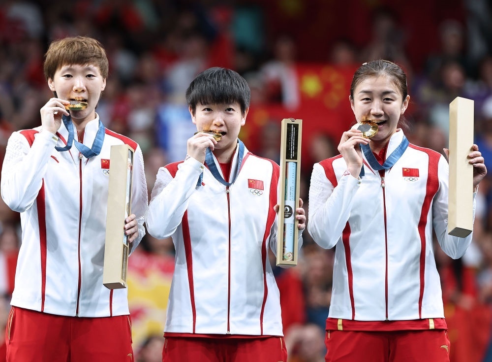 冠軍中國隊選手王曼昱、孫穎莎、陳夢（從左至右）在巴黎奧運會乒乓球女子團體頒獎儀式上（2024年8月10日攝）。新華社記者 王東震 攝