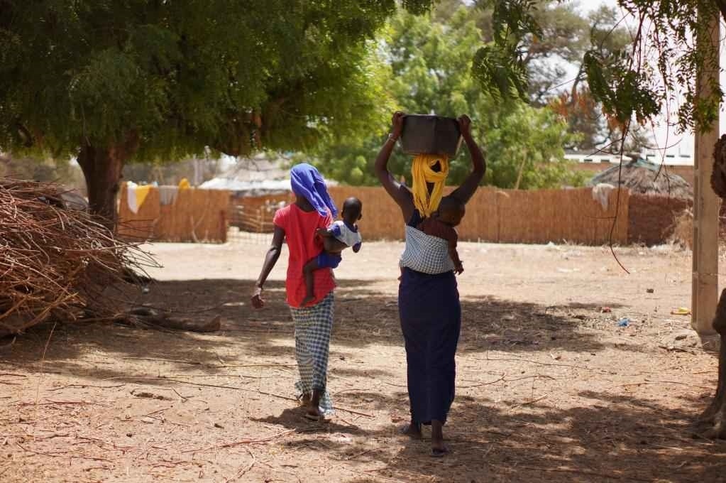 2023年3月20日，在塞內(nèi)加爾久爾貝勒區(qū)的泰內(nèi)富勒村，村民將取到的水運回家。新華社記者 王子正 攝