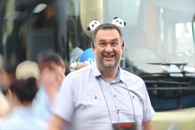 參訪熊貓谷前，塞爾維亞“一帶一路”研究所所長(zhǎng)博揚(yáng)·拉利奇戴上熊貓頭飾。（李佩藺 攝）