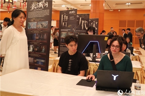 在活動(dòng)現(xiàn)場(chǎng)，當(dāng)?shù)孛癖婓w驗(yàn)“數(shù)字藏經(jīng)洞”云游戲，沉浸式體驗(yàn)敦煌文化。 人民網(wǎng)記者 李志偉攝