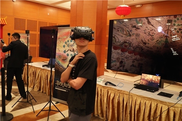 1、在本次活動(dòng)的展覽現(xiàn)場(chǎng)，敦煌研究院與騰訊展示了“數(shù)字藏經(jīng)洞”和“尋境敦煌”等創(chuàng)新互動(dòng)產(chǎn)品。圖為當(dāng)?shù)孛癖娡ㄟ^(guò)VR虛擬游覽洞窟。 人民網(wǎng)記者 李志偉攝