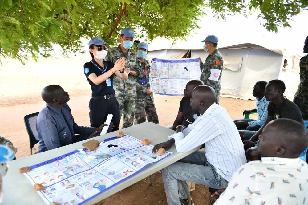 2020年3月，在南蘇丹首都朱巴，執(zhí)行聯(lián)合國維和任務(wù)的中國維和警察廖潔給當(dāng)?shù)鼐熘v解防疫知識(shí)。