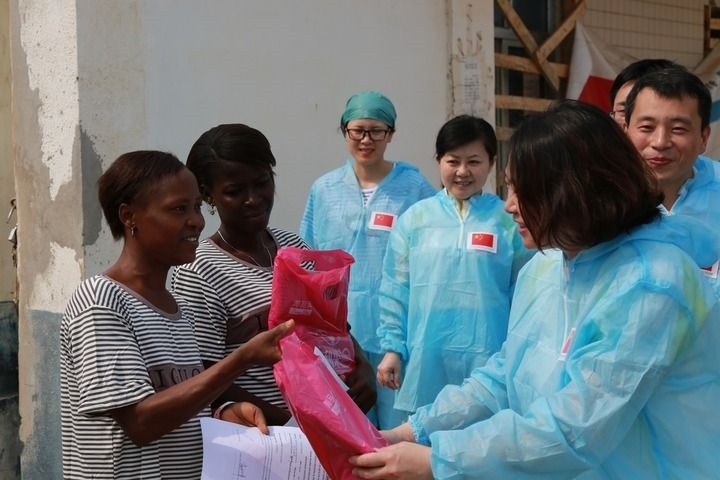 2015年4月4日，在位于塞拉利昂首都弗里敦市郊的中塞友好醫(yī)院埃博拉診療中心，中國第四批援塞醫(yī)療隊副隊長邵蔚（右前）向被治愈的埃博拉出血熱患者贈送禮物。新華社發(fā)（祖榮強 攝）