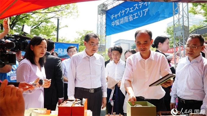 湖南展位工作人員向中國(guó)駐日本大使吳江浩介紹特色文創(chuàng)產(chǎn)品。人民網(wǎng) 蔣曉辰攝