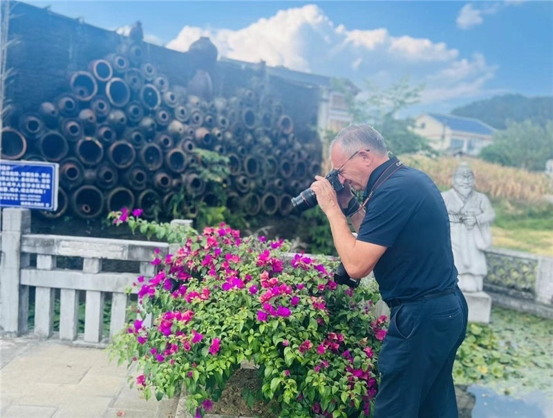 遠(yuǎn)處黔北民居錯(cuò)落有致，近處一只黑色的蝴蝶穿梭于粉紫色三角梅花叢間隙，與俄羅斯“大歐亞”總編輯弗拉基米爾·別列日內(nèi)赫的鏡頭玩起了捉迷藏，“你追我逃，不亦樂(lè)乎”。（張亞欣攝）