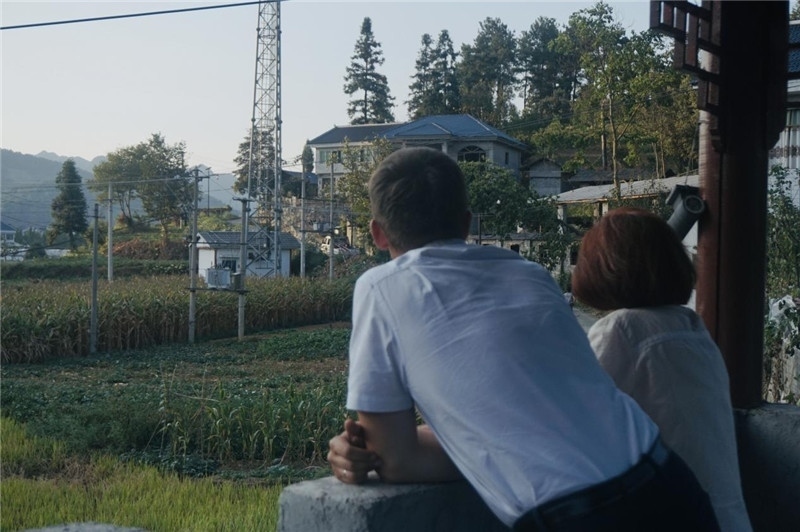 望得見(jiàn)山，看得見(jiàn)水，記得住鄉(xiāng)愁。每個(gè)人心中都有一個(gè)屬于自己的“花茂村”，在這方心田，走遍千山萬(wàn)水，鄉(xiāng)音未改鬢毛衰。吉爾吉斯斯坦《比什凱克晚報(bào)》第一副總編輯妮娜·尼奇博洛娃與《中國(guó)與俄羅斯》雜志社社長(zhǎng)奧列格·別列日內(nèi)赫攝在花茂村民居屋檐下并肩佇立，眺望山水，尋覓鄉(xiāng)愁。（李光裕攝）