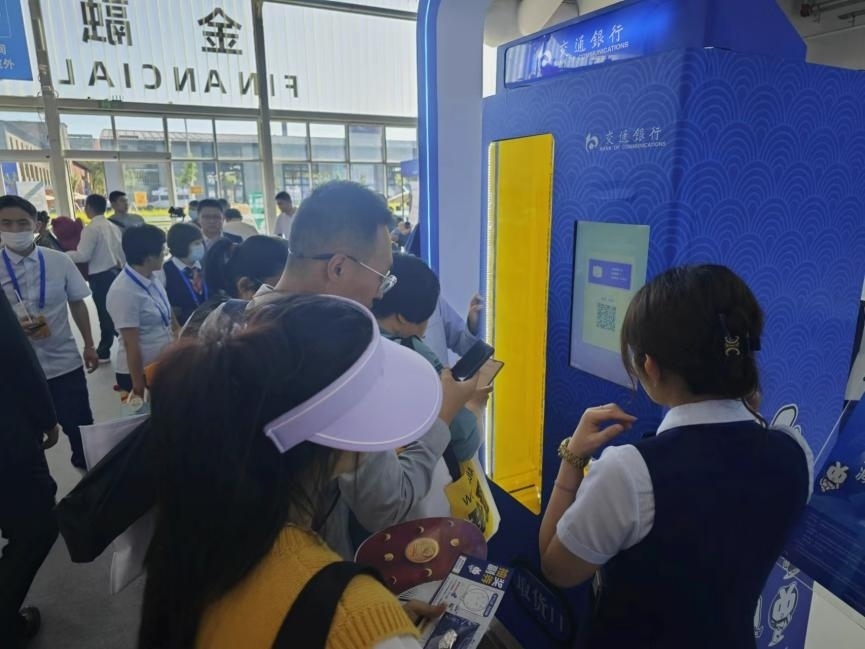 觀眾在金融服務(wù)展區(qū)體驗數(shù)字人民幣購物。人民網(wǎng)記者 黃盛攝