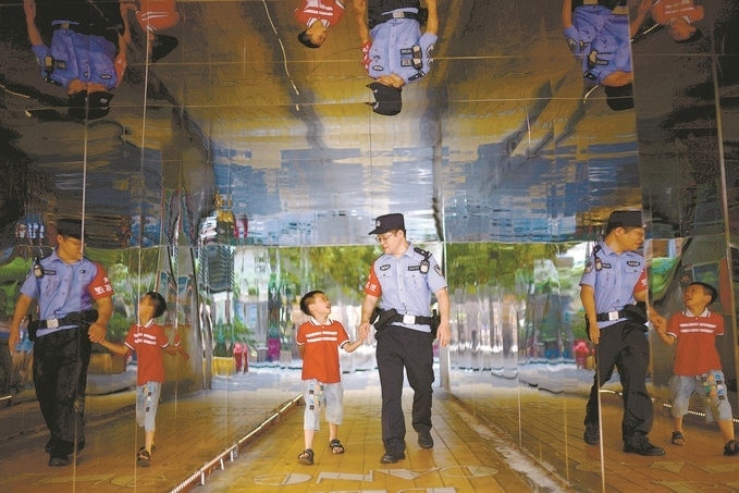 ?7月16日，重慶市公安局江北區(qū)分局一名民警在巡邏途中遇到一個(gè)獨(dú)自玩耍的小男孩，民警將其送回家。王洪平攝