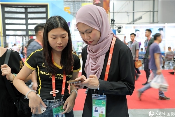 東博會現(xiàn)場，馬來西亞展商在同中方工作人員交談。人民網(wǎng)記者 趙益普攝